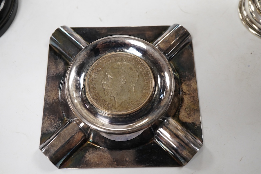A pair of George V small silver two handled trophy cups by J W Tiptaft & Son Ltd, Birmingham, 1933, height 10cm, one with plinth, together with a George V silver ashtray with inset coin base.